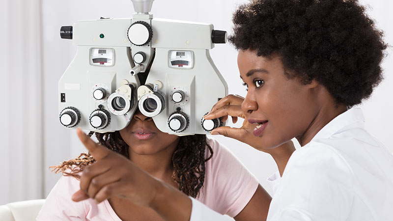 Optometrist doing an eye test on another person 