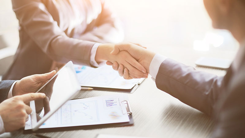 Business people shaking hands at table