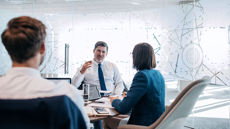 Business man speaking with peers at a table