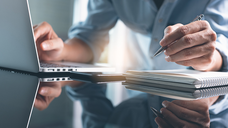 Man working on laptop and notebook