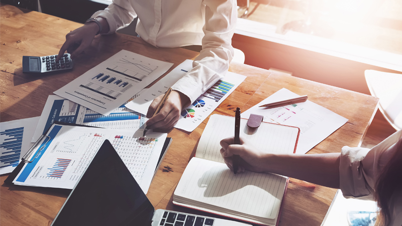 Working desk with paperwork, charts, and graphs