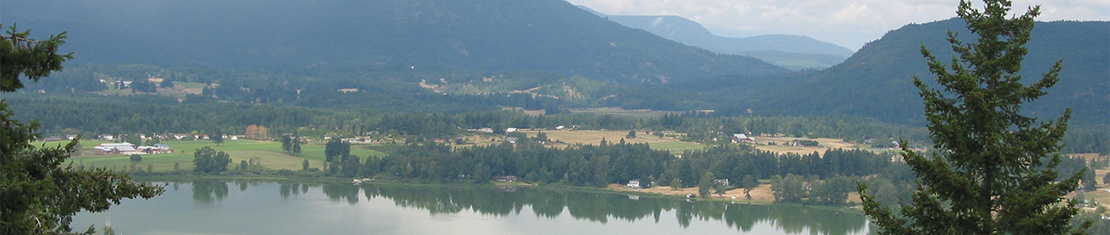 Farms in a valley surrounded by mountains.