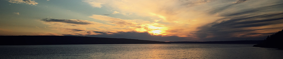 Orange and purple sunset over a wide body of water.