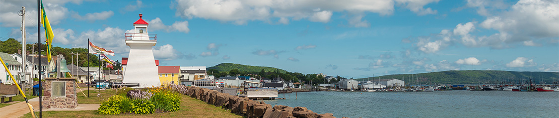 Red and white lighthouse overlooking a body of water.