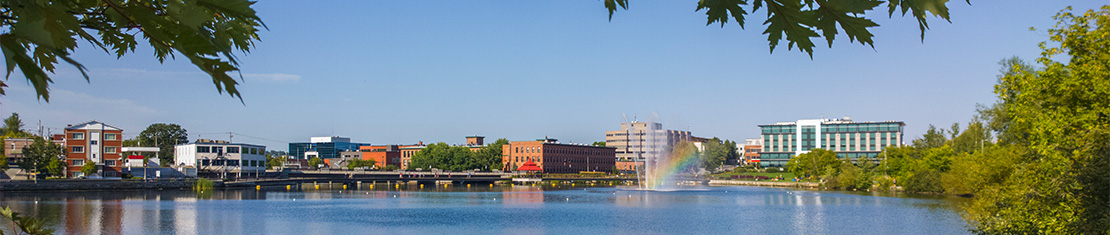 Body of water with a water fountain in front of office buildings