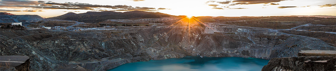 Bright blue lake in an abandoned, rocky mine hole